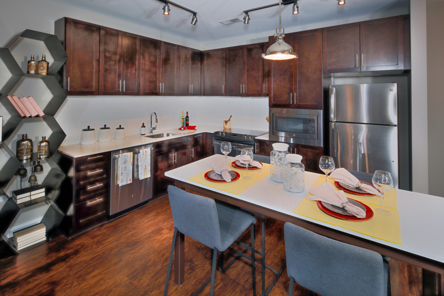 Kitchen with premium cabinetry, under-cabinet lighting, granite counters, islands and stainless steel appliances